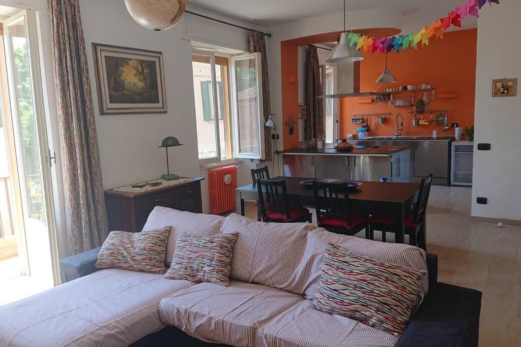 uma sala de estar com um sofá branco e uma cozinha em Appartamento La Valle em Passignano sul Trasimeno