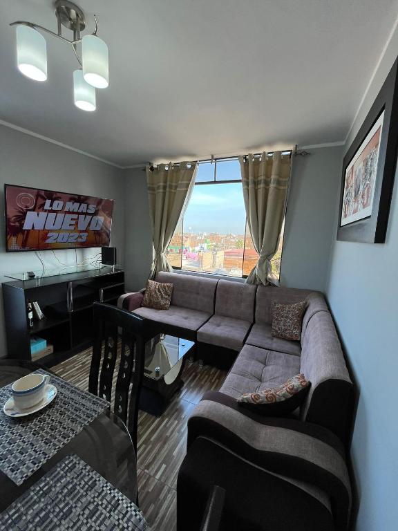 un soggiorno con divano e tavolo di Apartamento Con Estilo A 4 Min Del Aeropuerto-6 Piso! a Lima