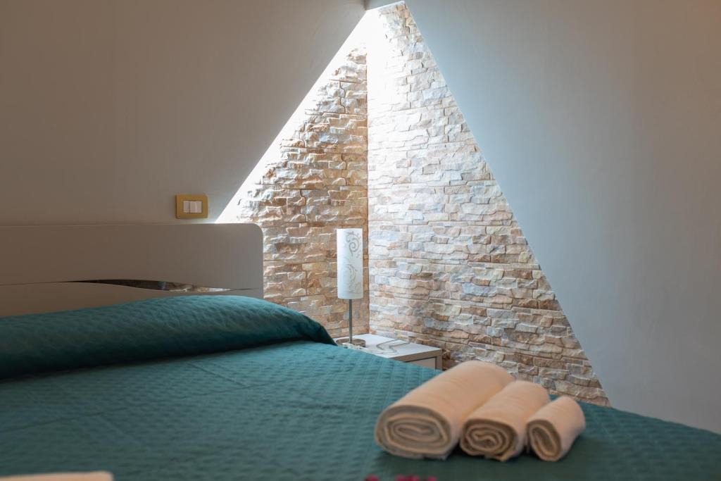a bedroom with a bed with two pairs of slippers at B&B al Vico Pepe in Castelmezzano