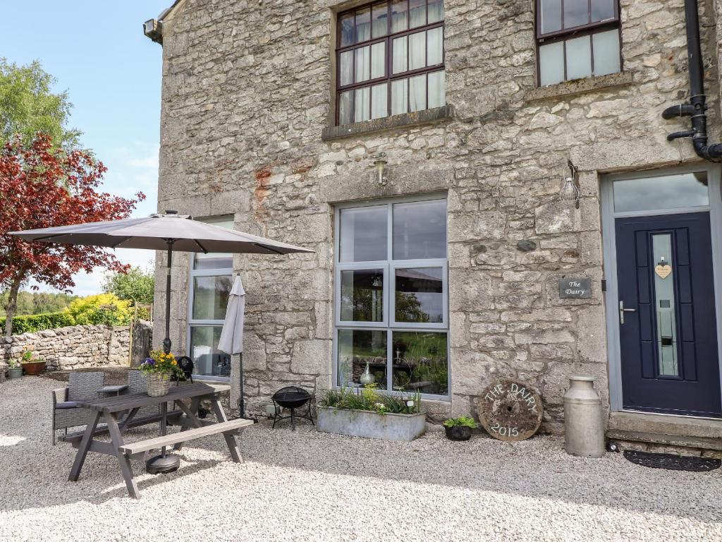 a table and an umbrella in front of a building at The Dairy in Carnforth