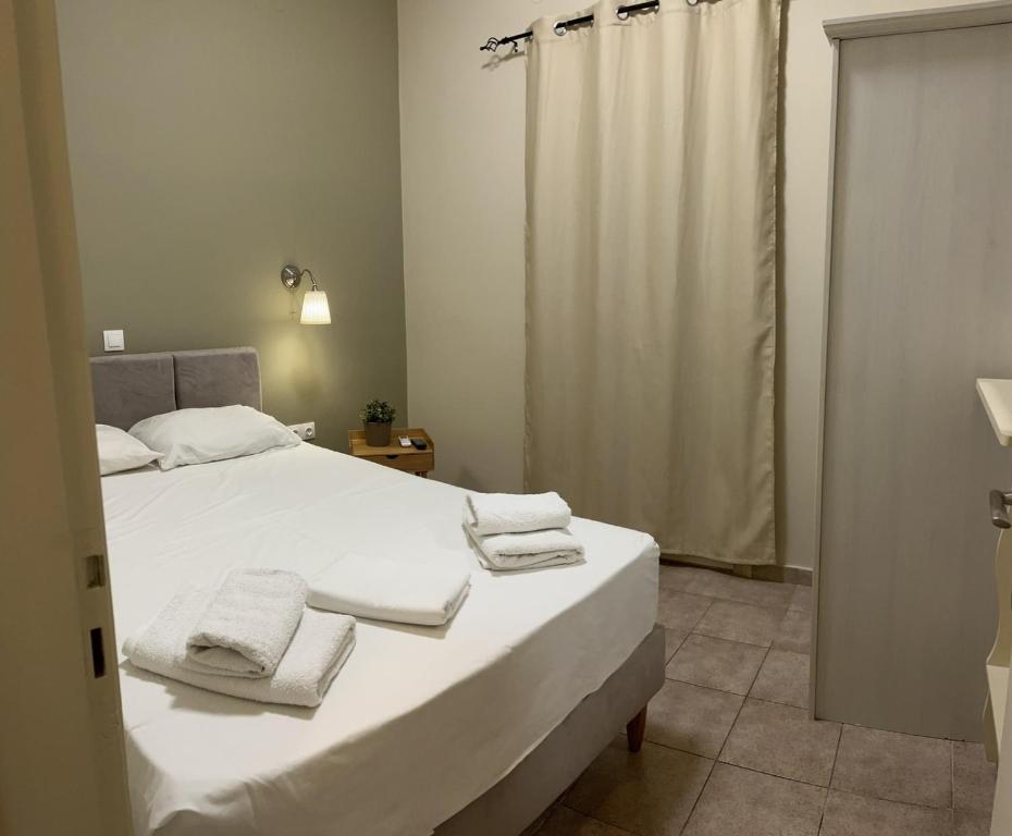 a bedroom with a large white bed with towels on it at Maro's Apartments in Argostoli