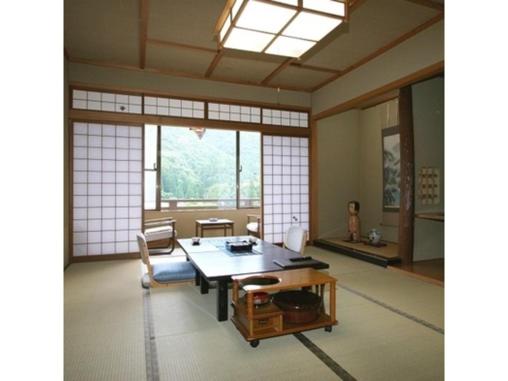 um quarto com uma mesa e cadeiras e uma janela em Oyasukyo Onsen Ryokan Tarobee - Vacation STAY 56805v em Yuzawa