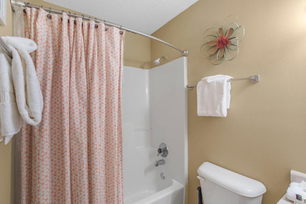 a bathroom with a shower curtain and a toilet at The Dunes 502 by Vacation Homes Collection in Gulf Shores