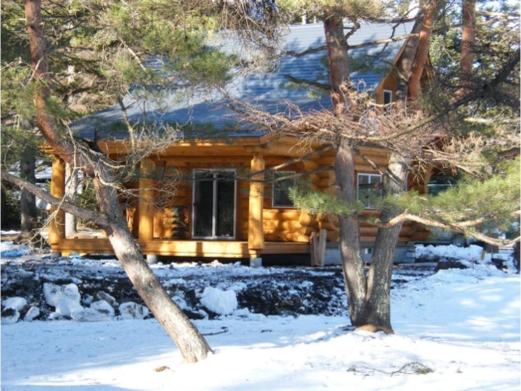 a log cabin in the snow with a tree at Karuizawa Sunny Village - Vacation STAY 57953v in Karuizawa
