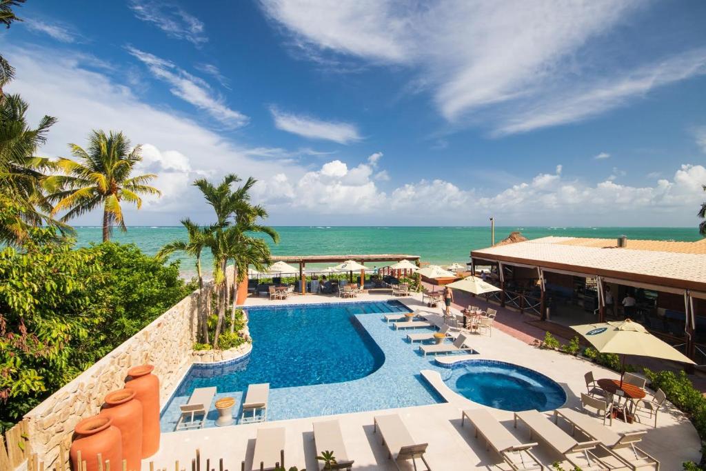 uma imagem de um resort com uma piscina e o oceano em Árvo Boutique Hotel em Maragogi
