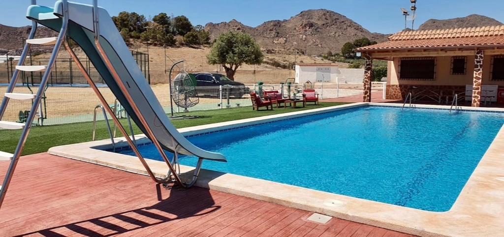 una piscina con un tobogán junto a una casa en Villa vacacional Águilas, en Águilas