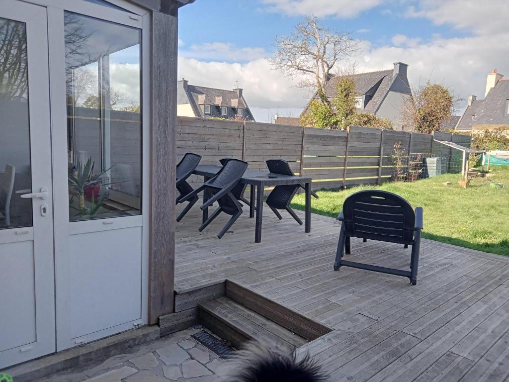 un patio avec des chaises et une table sur une terrasse dans l'établissement la tiny aux portes de brest, à Guilers