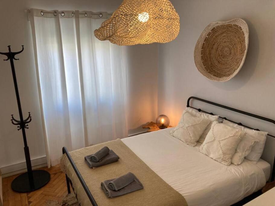 a bedroom with a bed with two towels on it at Apartamento bem localizado para famílias & amigos in Lisbon