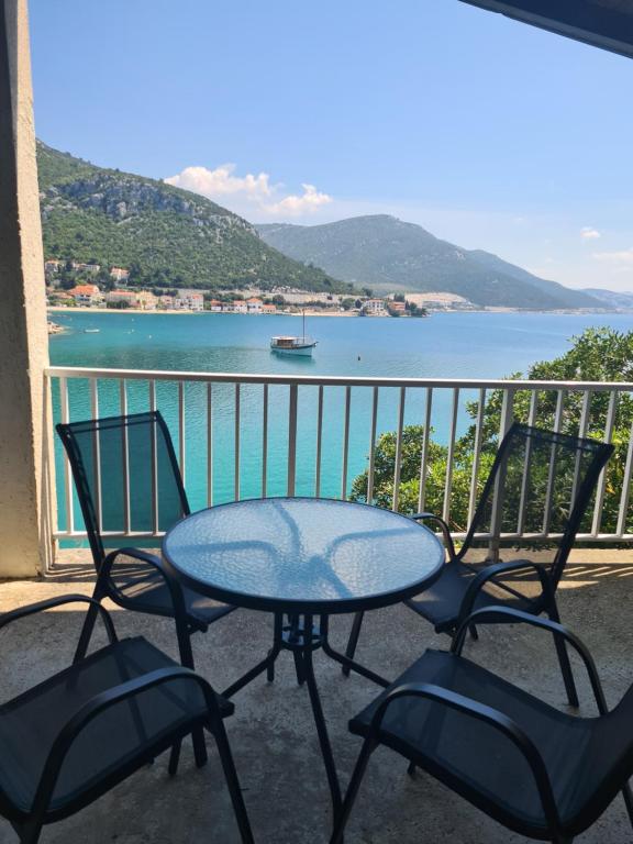 クレックにあるBlue Lagoon Studio Apartmentsのテーブルと椅子、水辺の景色を望むバルコニー