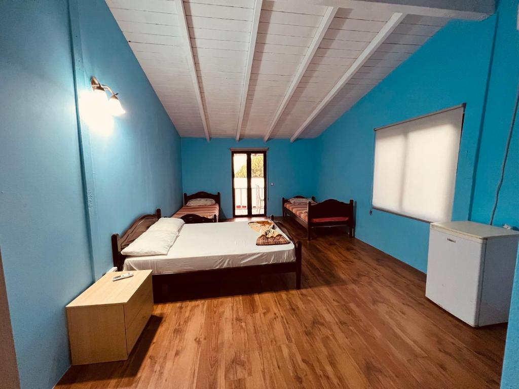 um quarto com uma cama e uma parede azul em Favela Chic Room em Durrës