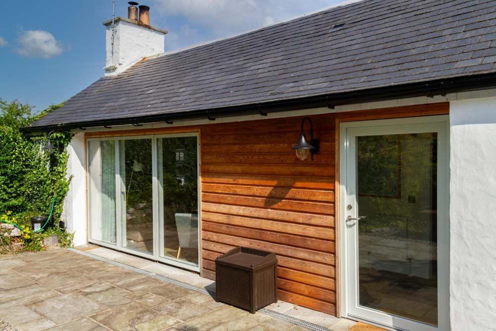 a house with sliding glass doors on a patio at Skerrow in New Galloway