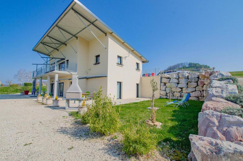 a large white house with a stone wall at Le grand clos in Meurville