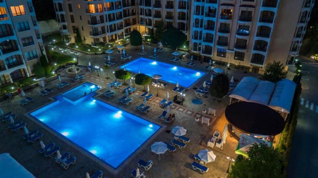 an overhead view of a large pool in a city at night at Bendita Mare Apartment in Golden Sands