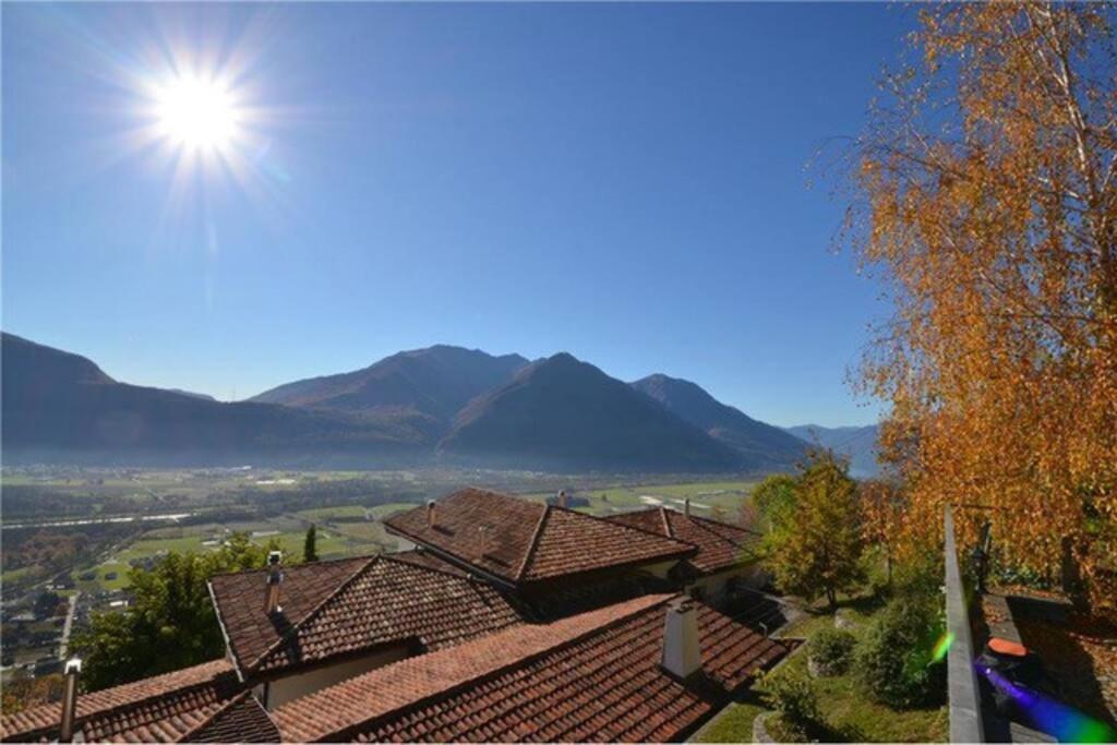 una vista de los tejados de las casas con montañas en el fondo en Un sogno nella natura, en Agarone