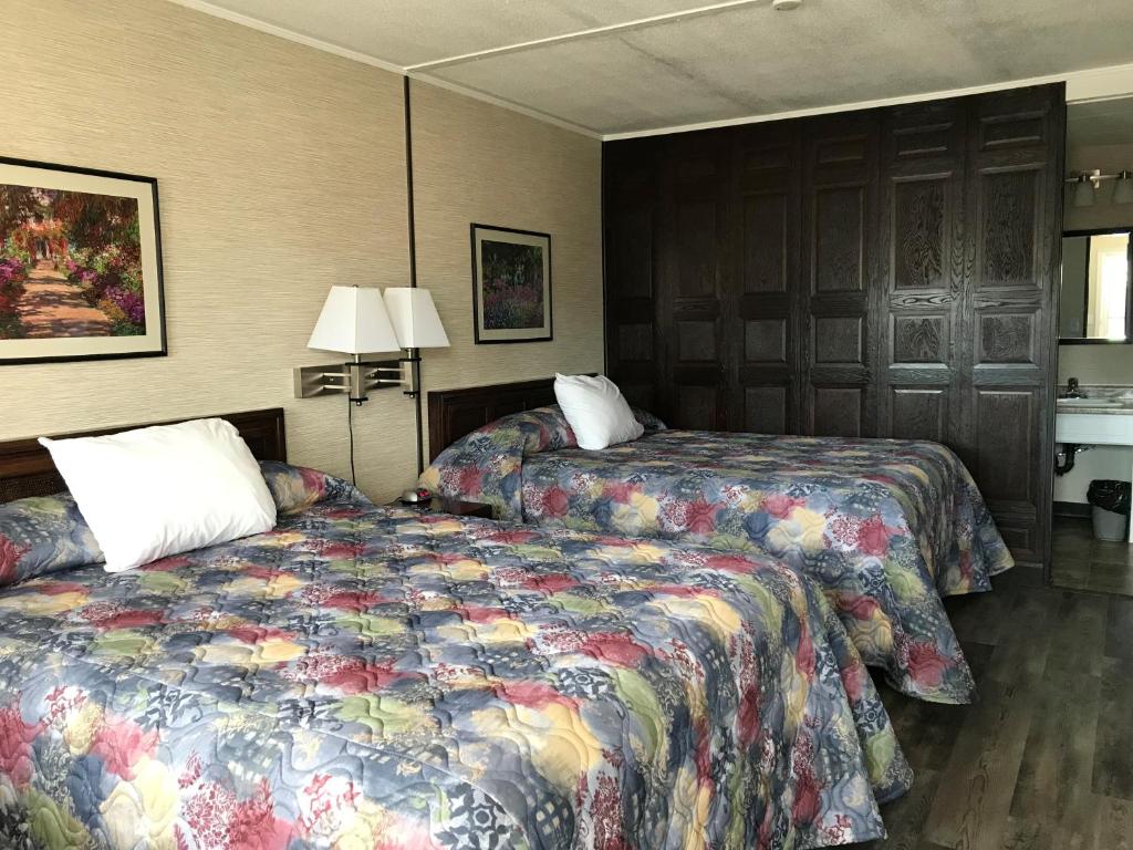 une chambre d'hôtel avec deux lits et une lampe dans l'établissement Tay Inn, à Perth