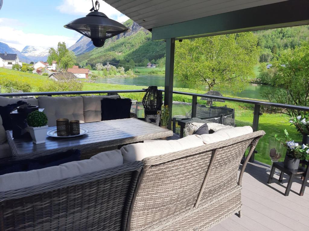 a patio with two wicker chairs and a table on a deck at Stryn Sentrum 3 soverom in Stryn