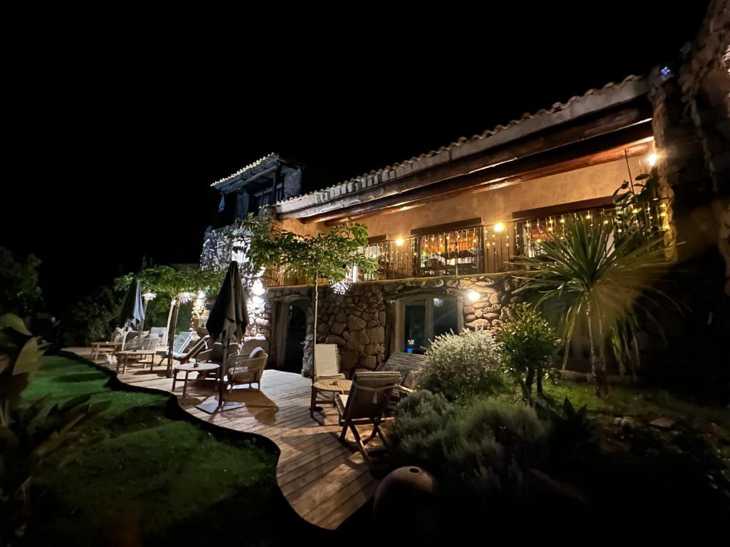a house with a patio at night at Hôtel Ambassador Palombaggia in Porto-Vecchio