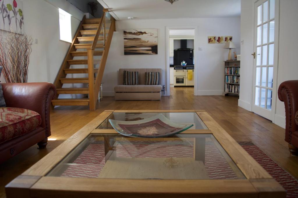 a living room with a coffee table and stairs at Coach House. Falcon Mews in Bude
