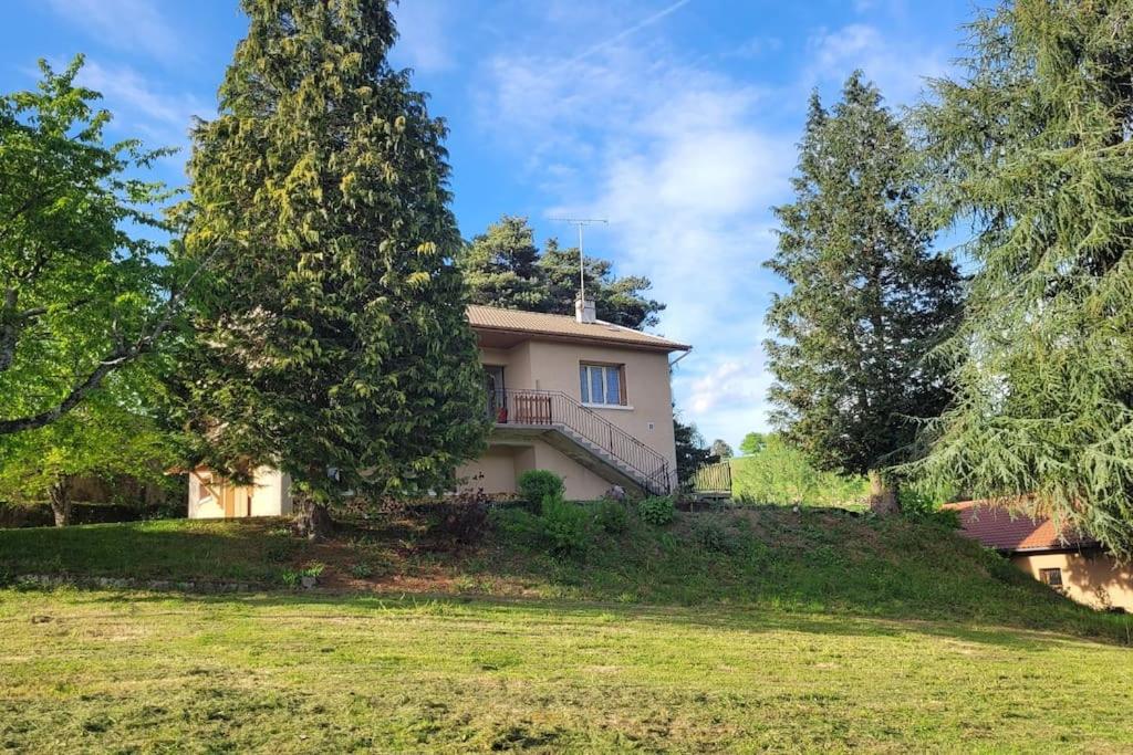 una casa en una colina con árboles en Maison à la campagne, au calme, en Olliergues