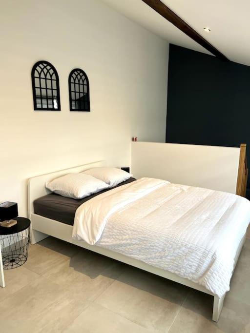 1 dormitorio con 1 cama blanca grande en una habitación en Appartement Duplex avec jardin, en Ingersheim