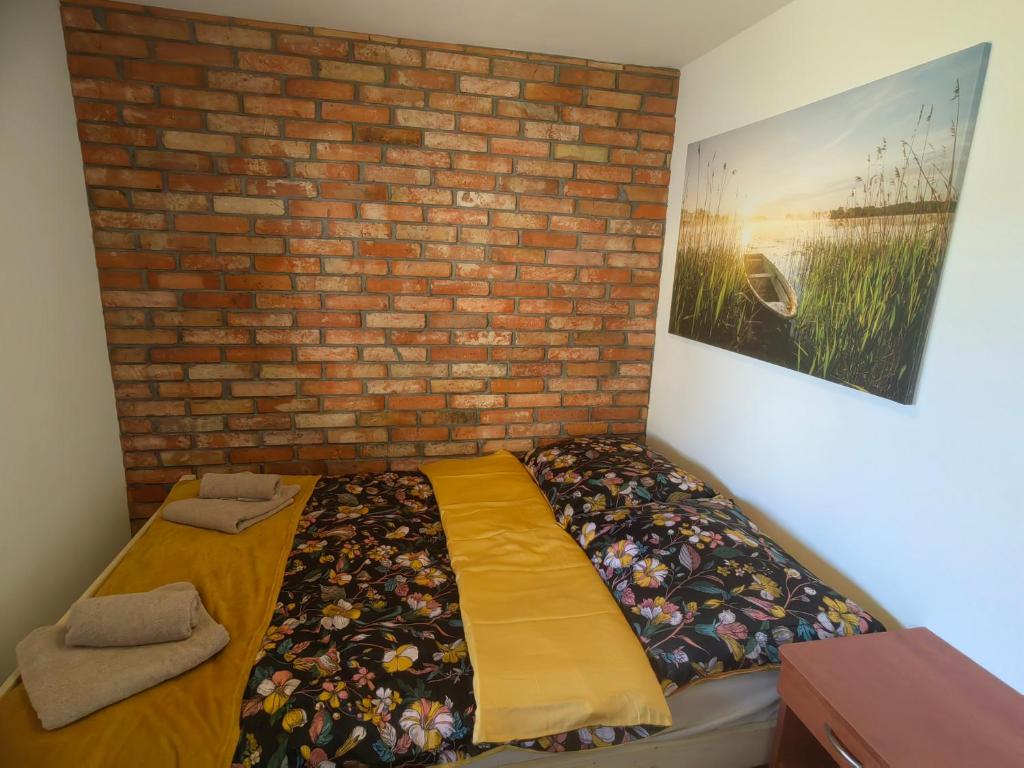 a bedroom with a bed against a brick wall at Siedlisko PoMaLeńku in Żarnowska