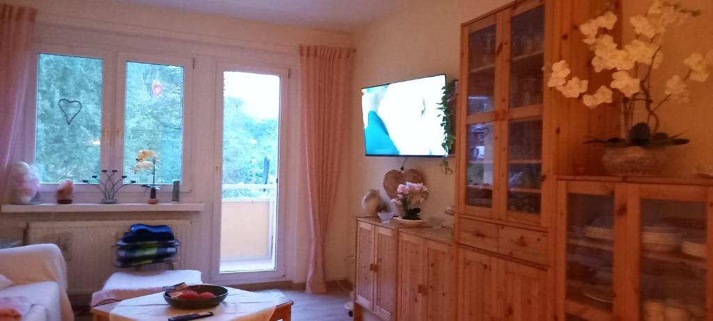 een woonkamer met een tv en een groot raam bij Apartment mit Herz in Sondershausen