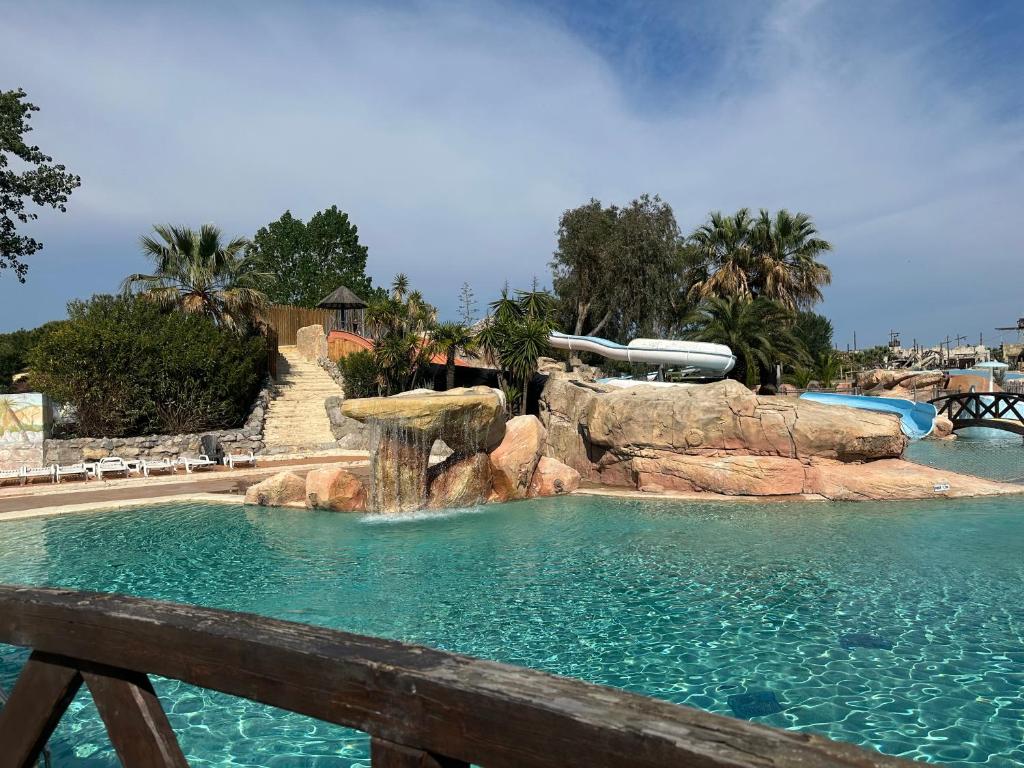 une piscine avec cascade dans un parc aquatique dans l'établissement Mobil home les sables d or, au Grau-dʼAgde