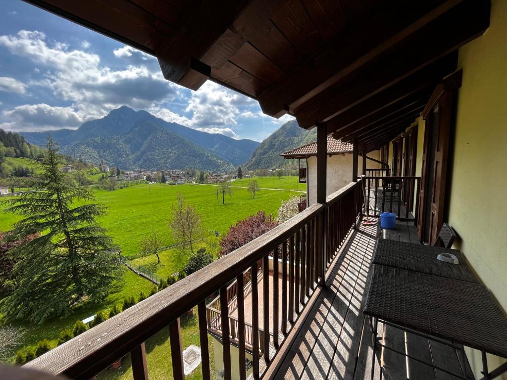 uma varanda com vista para um campo verde e para as montanhas em Appartamenti Casa Miravalle em Enguiso