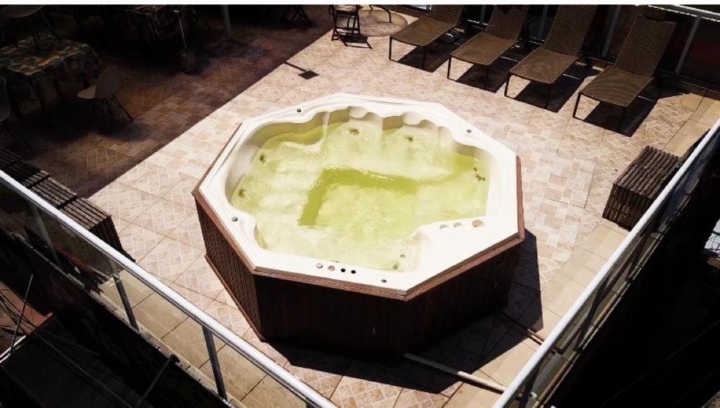 bañera grande con suelo de baldosa en Pousada Las Palmas en Guarujá