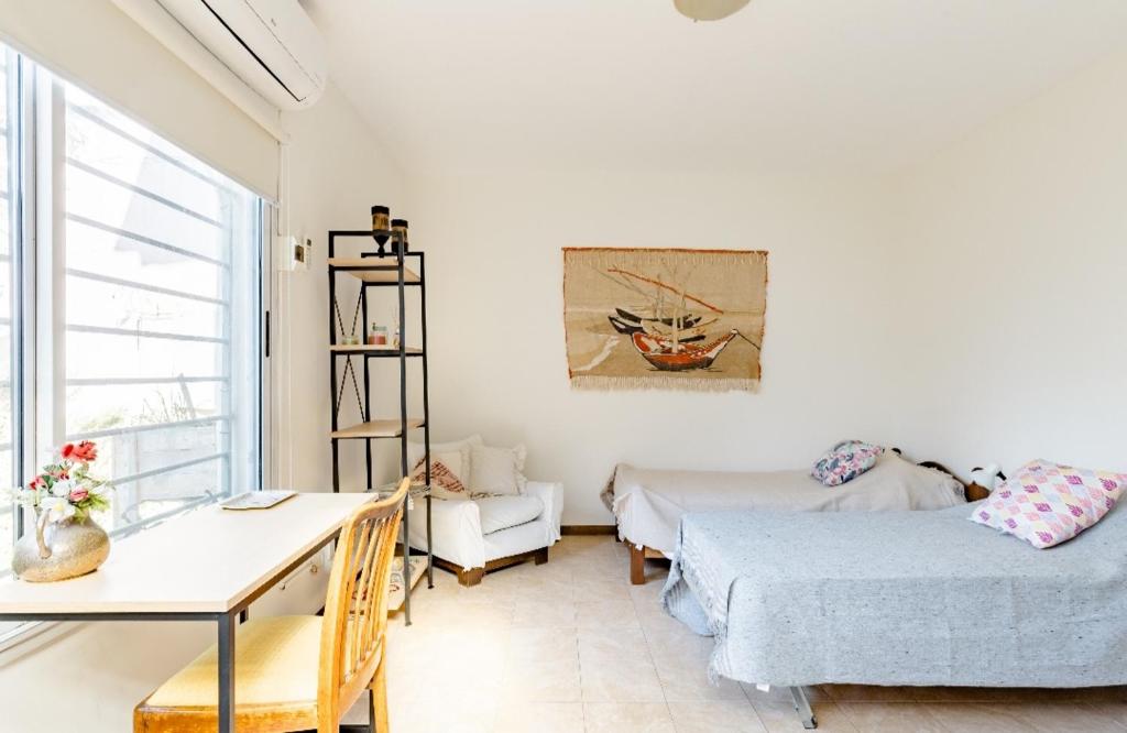 um quarto com 2 camas, uma mesa e uma secretária em Habitación con baño privado Regis Haus em Villa Adelina