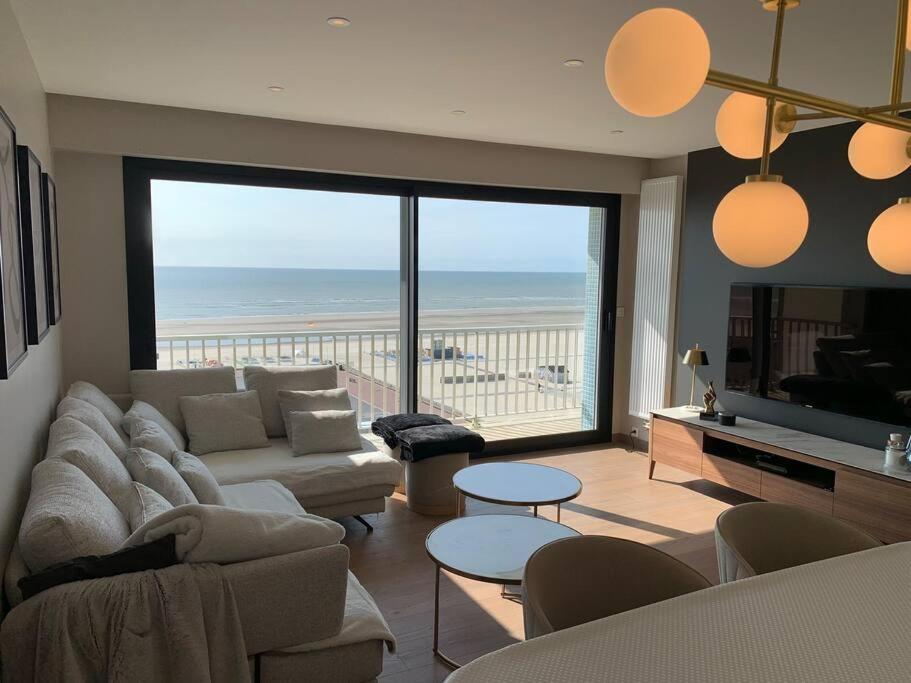 un salon avec un canapé et une vue sur l'océan dans l'établissement Résidence le Concorde, à Le Touquet-Paris-Plage