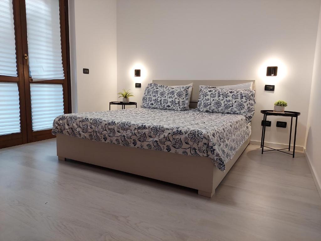 um quarto com uma cama com duas mesas e duas almofadas em G&G House em Milão