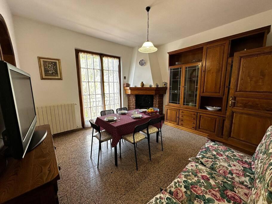 uma sala de estar com uma mesa com cadeiras e uma televisão em Tra le Alpi Apuane e il mare em Montignoso
