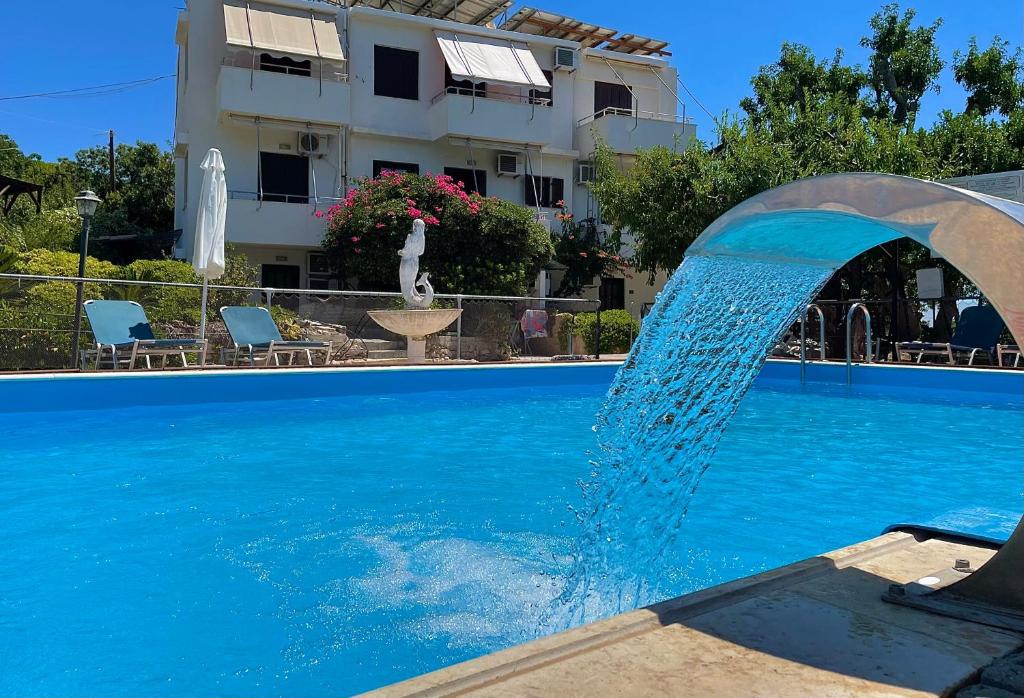 a water fountain in front of a swimming pool at Vasilikos Apartments in Paralia Agias Foteinis