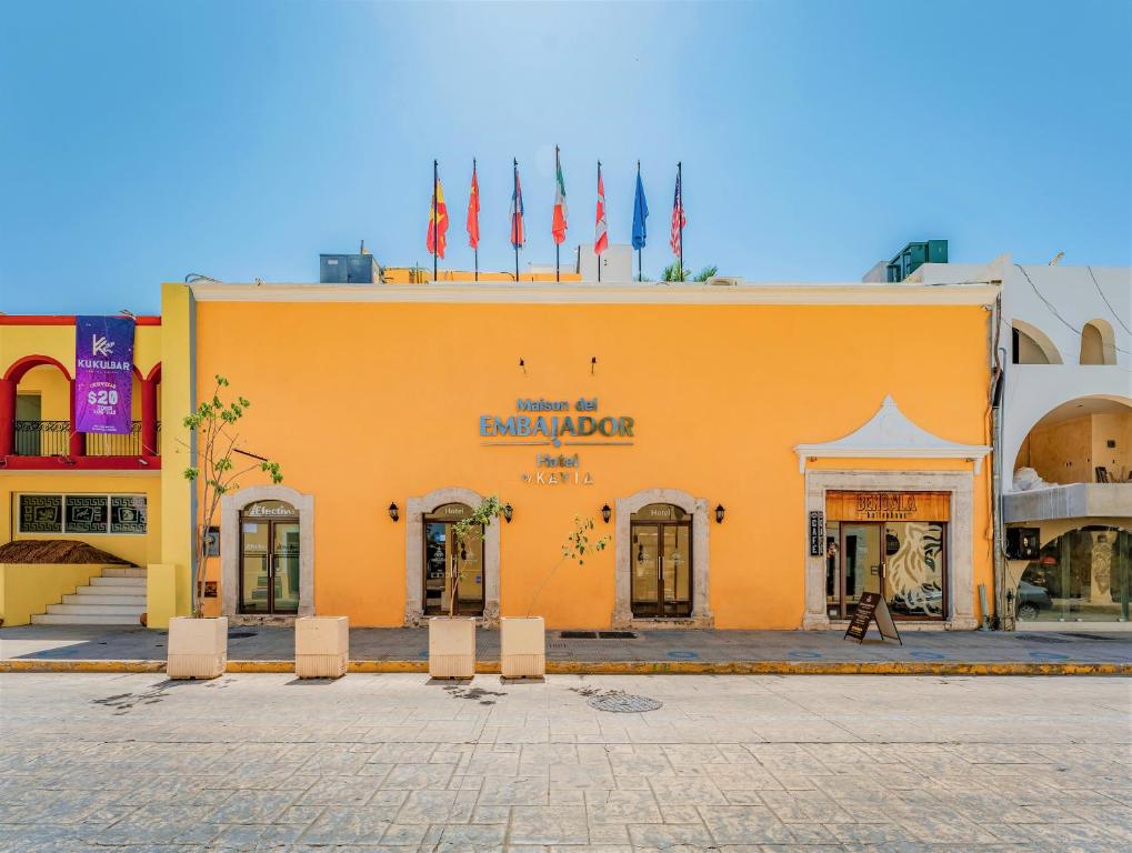 un edificio amarillo con banderas encima en Maison del Embajador, en Mérida