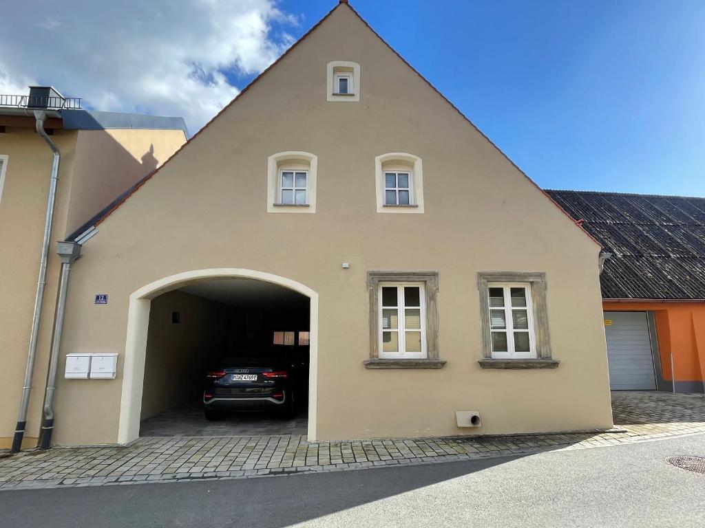 a house with a garage with a car in it at Apartment in zentraler Lage mit Privatparkplatz in Gravenwerth