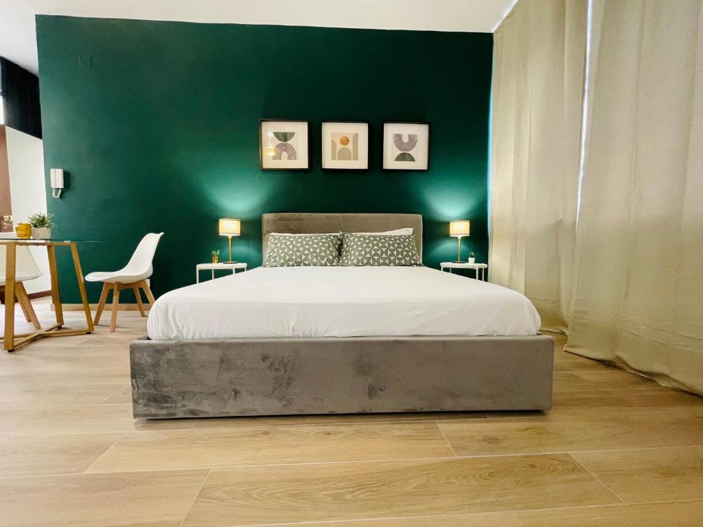 a bedroom with a large bed with a green wall at Le Dimore del Corso in Catania