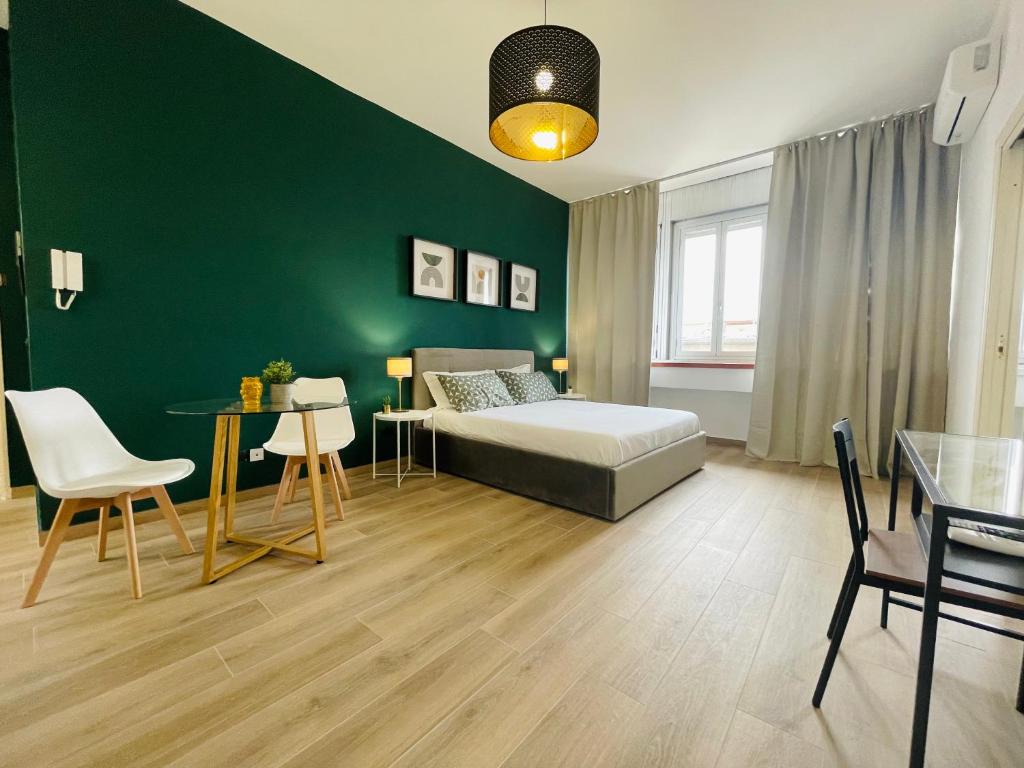 una camera con letto e parete verde di Le Dimore del Corso a Catania