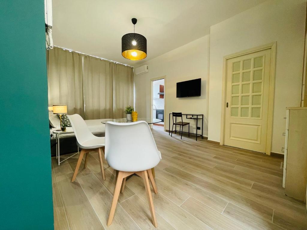 a dining room with a table and white chairs at Le Dimore del Corso in Catania
