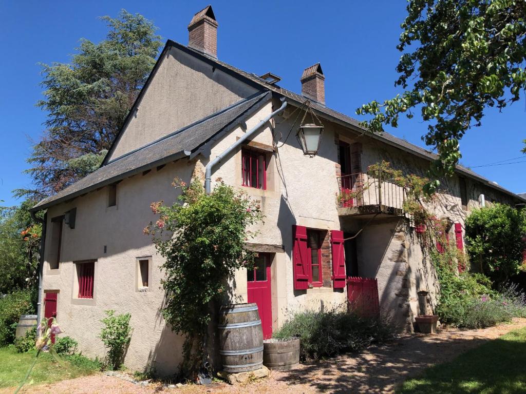 una vieja casa blanca con persianas rojas en Grande maison familiale, rustique et charmante en Bourgogne, dans le Morvan, en Dun-sur-Grandry