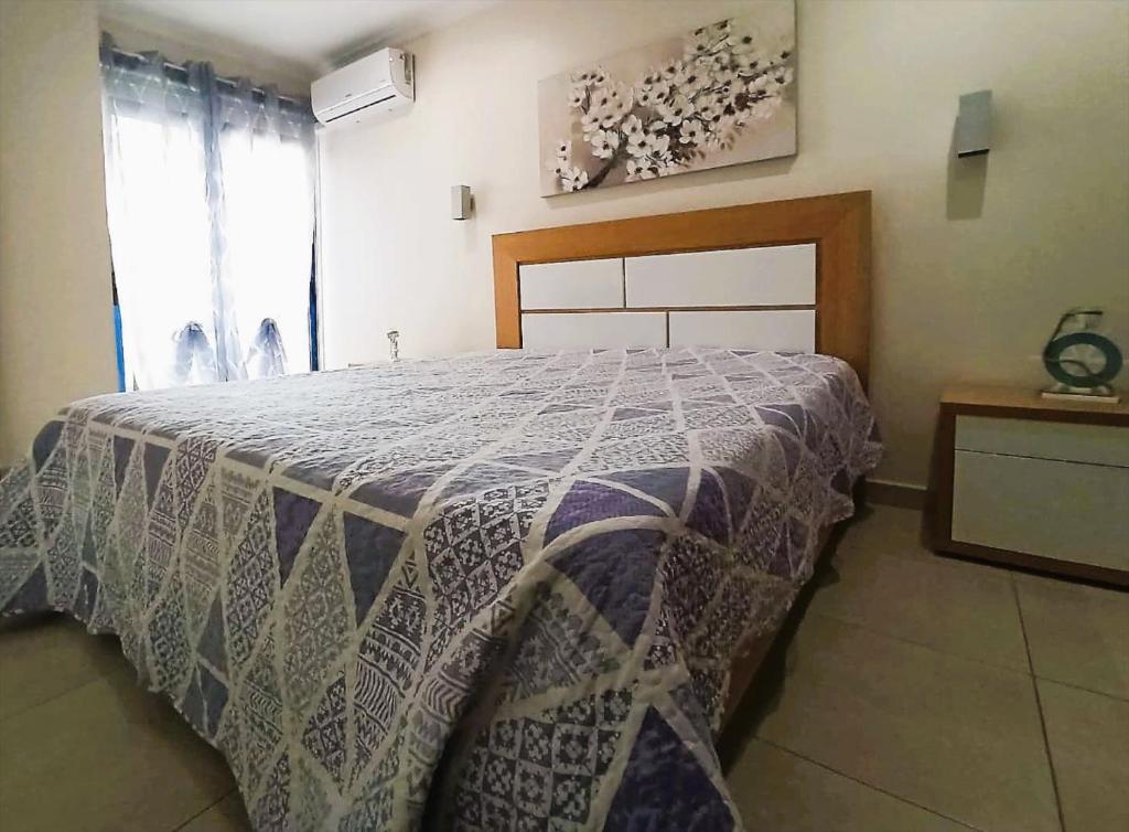 um quarto com uma cama com um cobertor azul e branco em Blue Beach em Portimão