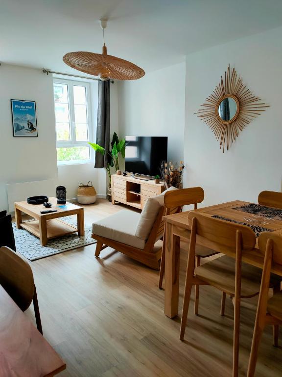 un salon avec une table et une télévision dans l'établissement Superbe T2 Aux Pieds des Cimes, lumineux, calme, classé 4 étoiles, à Bagnères-de-Bigorre
