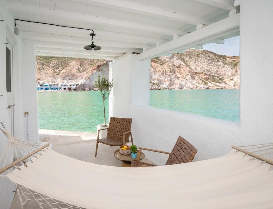 a porch with chairs and a view of the water at Thavma Milos in Firopótamos