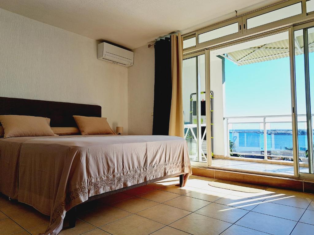 - une chambre avec un lit et une grande fenêtre dans l'établissement FARE NATIHERE, à Papeete