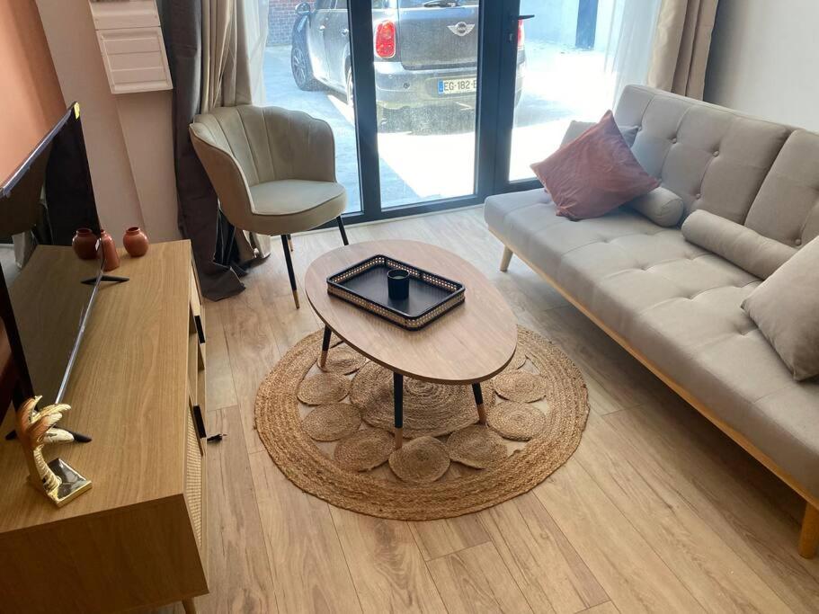 a living room with a couch and a table at Appart 1 chambre neuf confort in Rouen