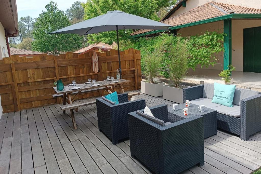 a patio with a table and chairs and an umbrella at Duplex House With Large Terrace And Garden in Moliets-et-Maa