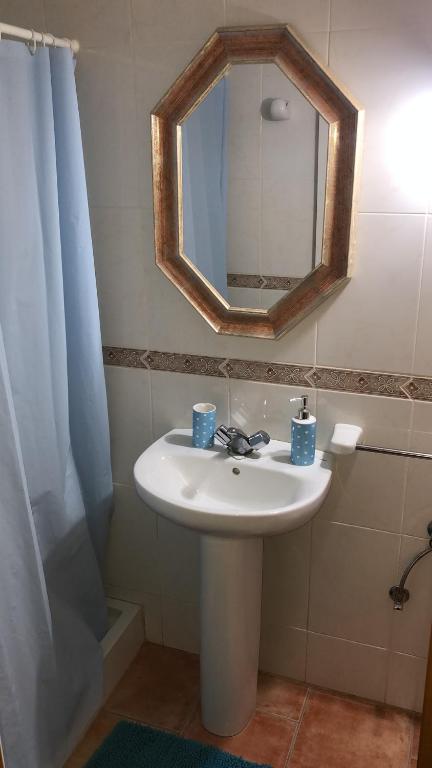 y baño con lavabo y espejo. en Apart Calan Forcat Menorca, en Cala en Forcat