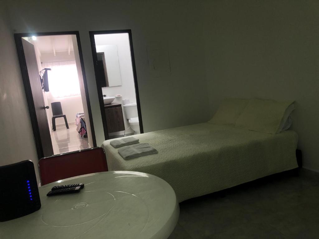 een kleine slaapkamer met een bed, een tafel en een raam bij Apartamento cómodo, céntrico y bien ubicado apto 404 in Medellín