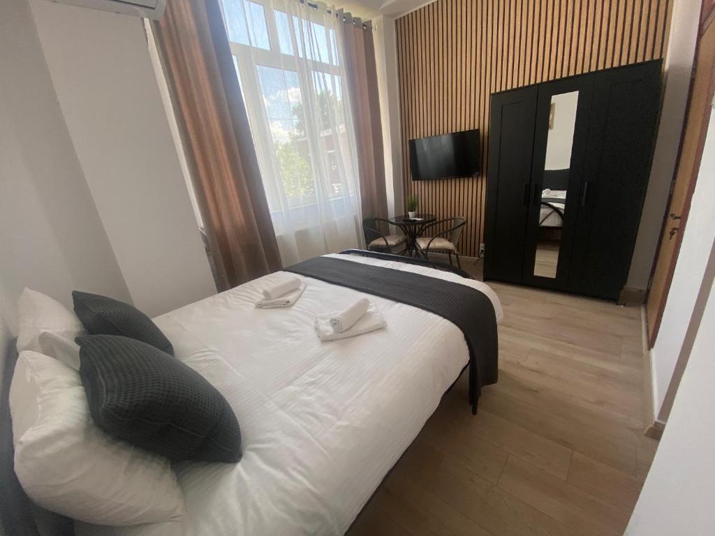 1 dormitorio con cama blanca y ventana grande en Garsoniera 27mp - Camera - Baie - Bucatarie - Balcon en Mogoşoaia