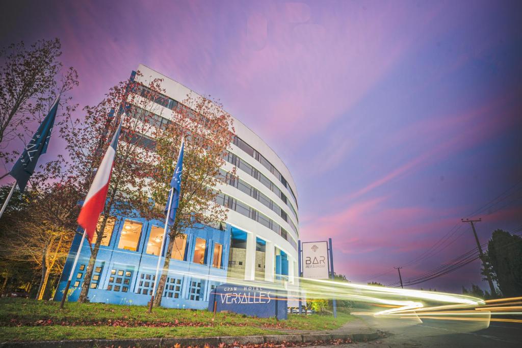 un edificio con una bandiera davanti di Gran Hotel Versalles Puerto Montt a Puerto Montt